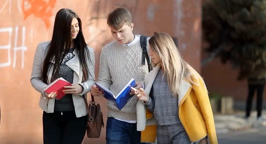 Three students engage in a focused discussion