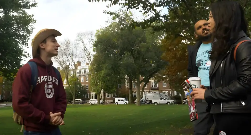 Students engage in conversation on a sunny Harvard campus