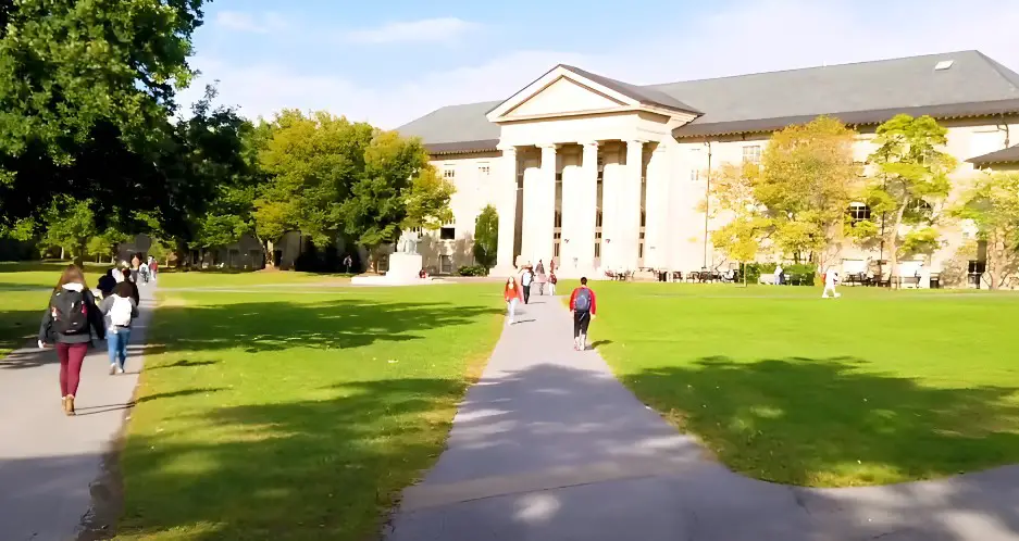 Students stroll across the manicured lawn at Cornell University Campus